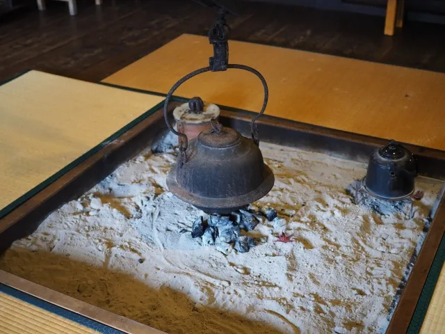 囲炉裏に鉄のやかんがかかっている