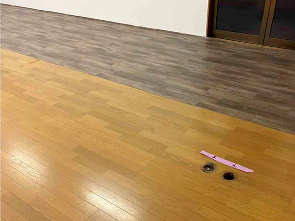 フローリングの上に長尺塩ビシートを張っていく様子