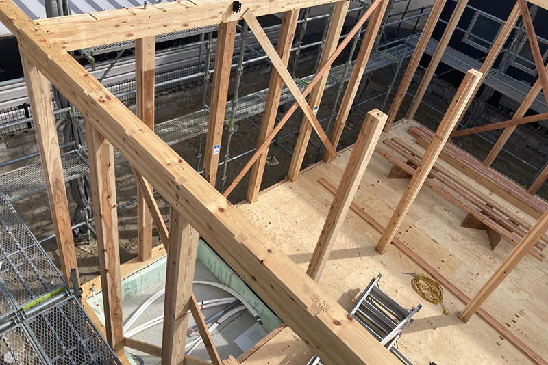 木造新築の骨組み作業と足場が設置された上棟中の建築現場